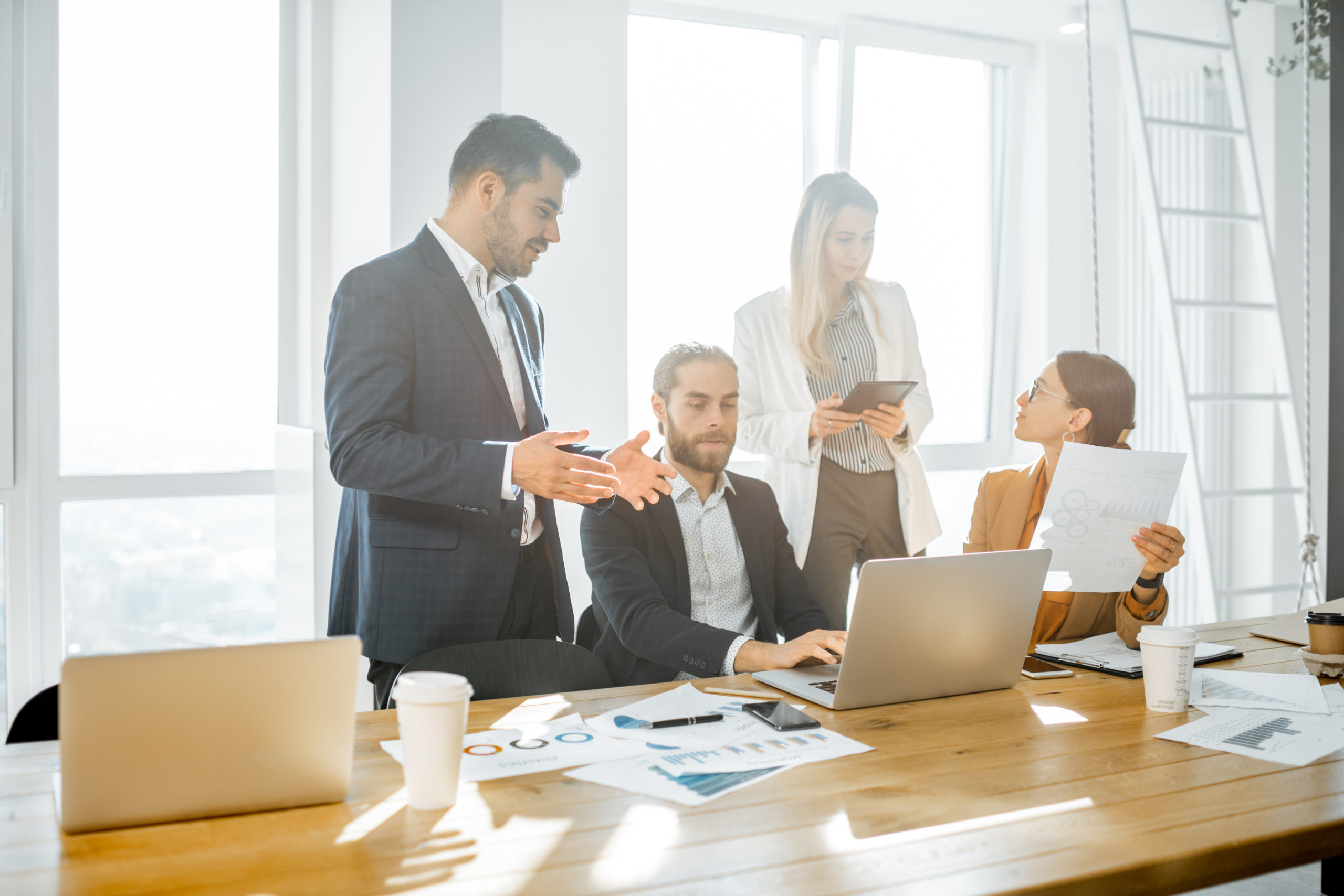 Agile Führung: Mehrere Mitarbeiterinnen stehen zusammen und erarbeiten Lösungen.