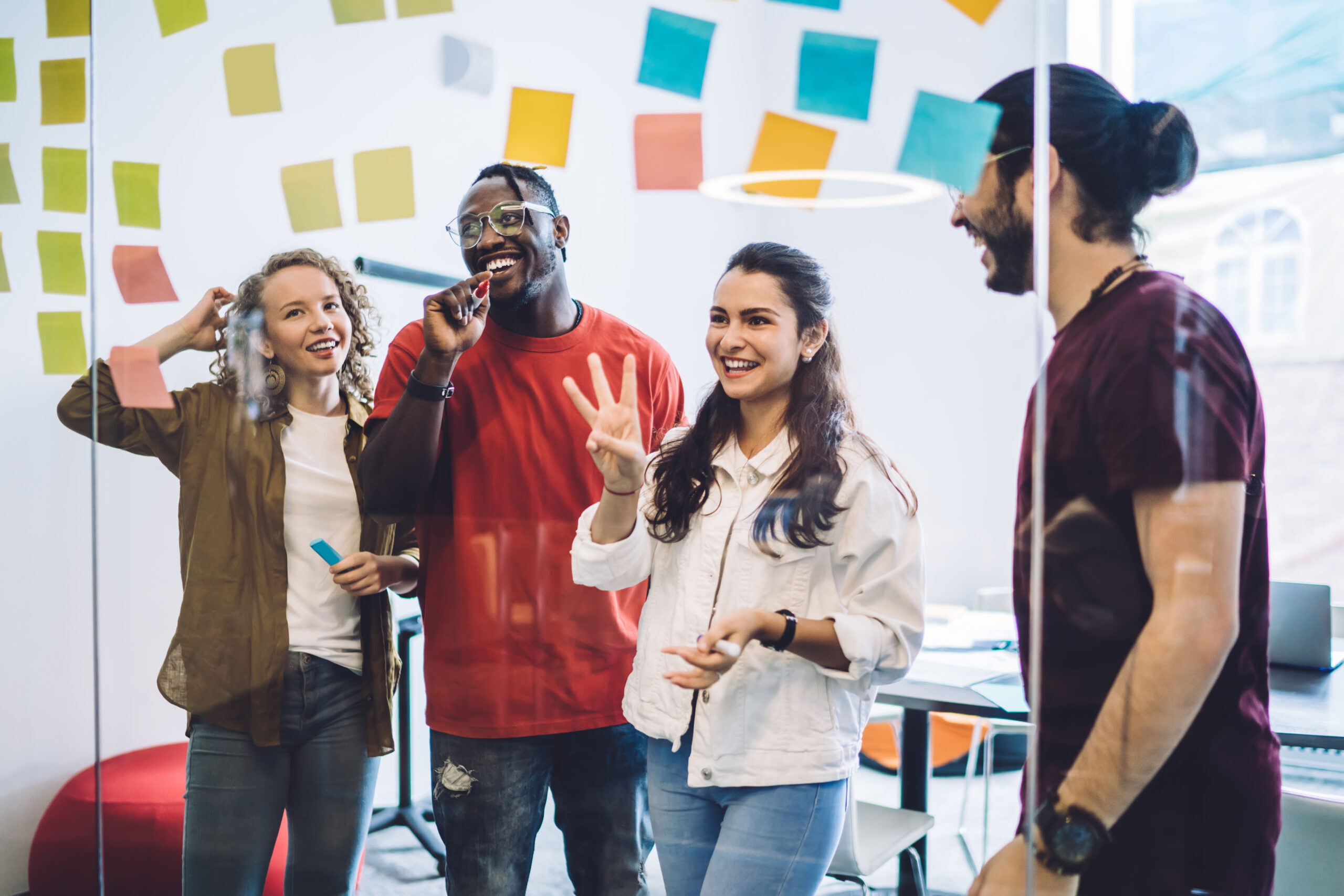 Mehrere junge Mitarbeiterinnen von contec stehen vor einem Whiteboard und tragen etwas vor.