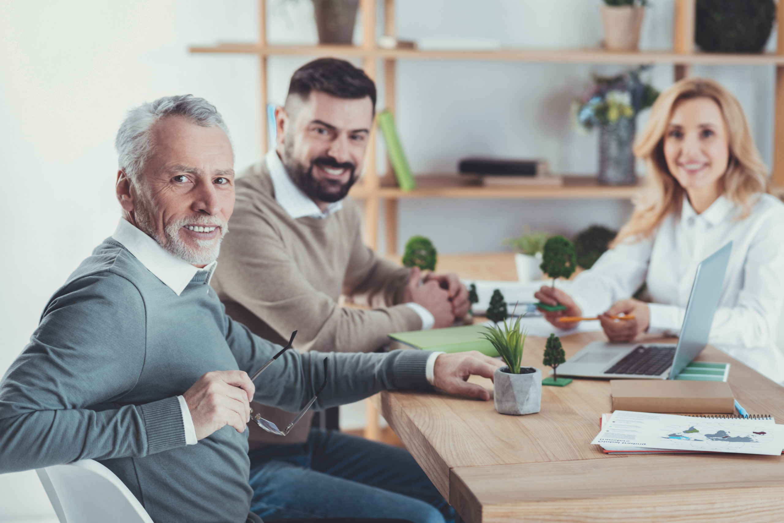 Ein älterer Mitarbeiter sitzt am Tisch neben einem jüngeren Vorgesetzten, der das Interim-Management übernommen hat.